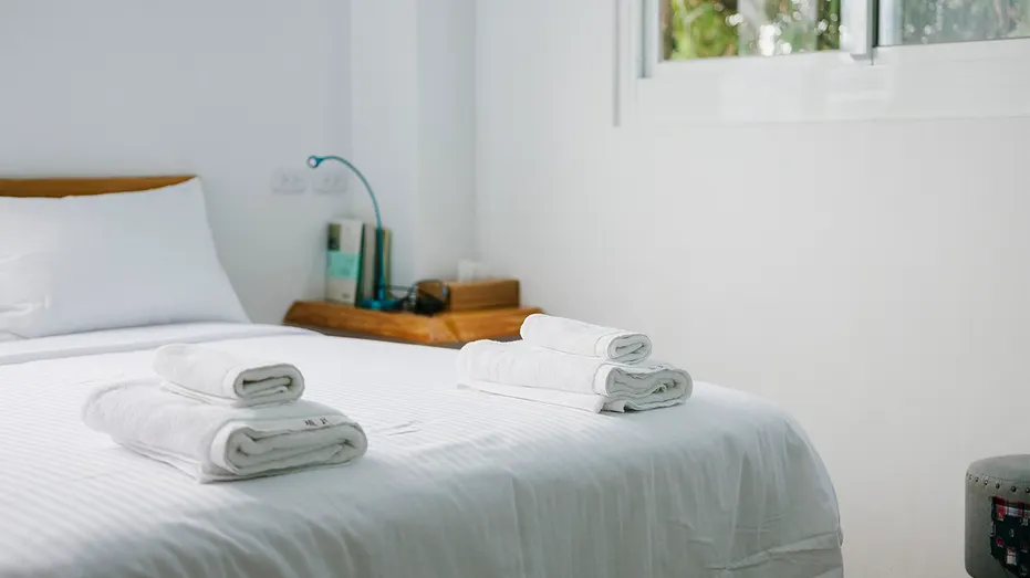 Clean Airbnb bedroom with clean towels nicely folded on top